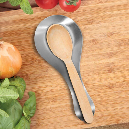 Stainless steel spoon rest with wooden spoon on kitchen counter with vegetables